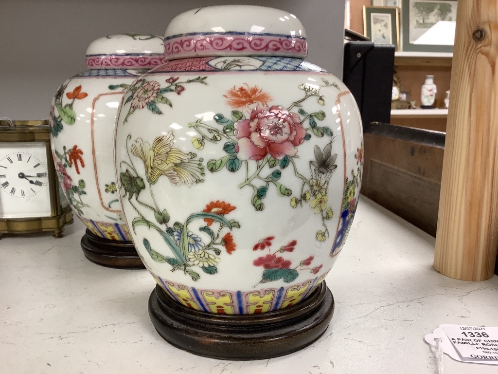 A pair of Chinese famille rose jars and covers, late 19/early 20th century, 15.5cm, on hardwood stands